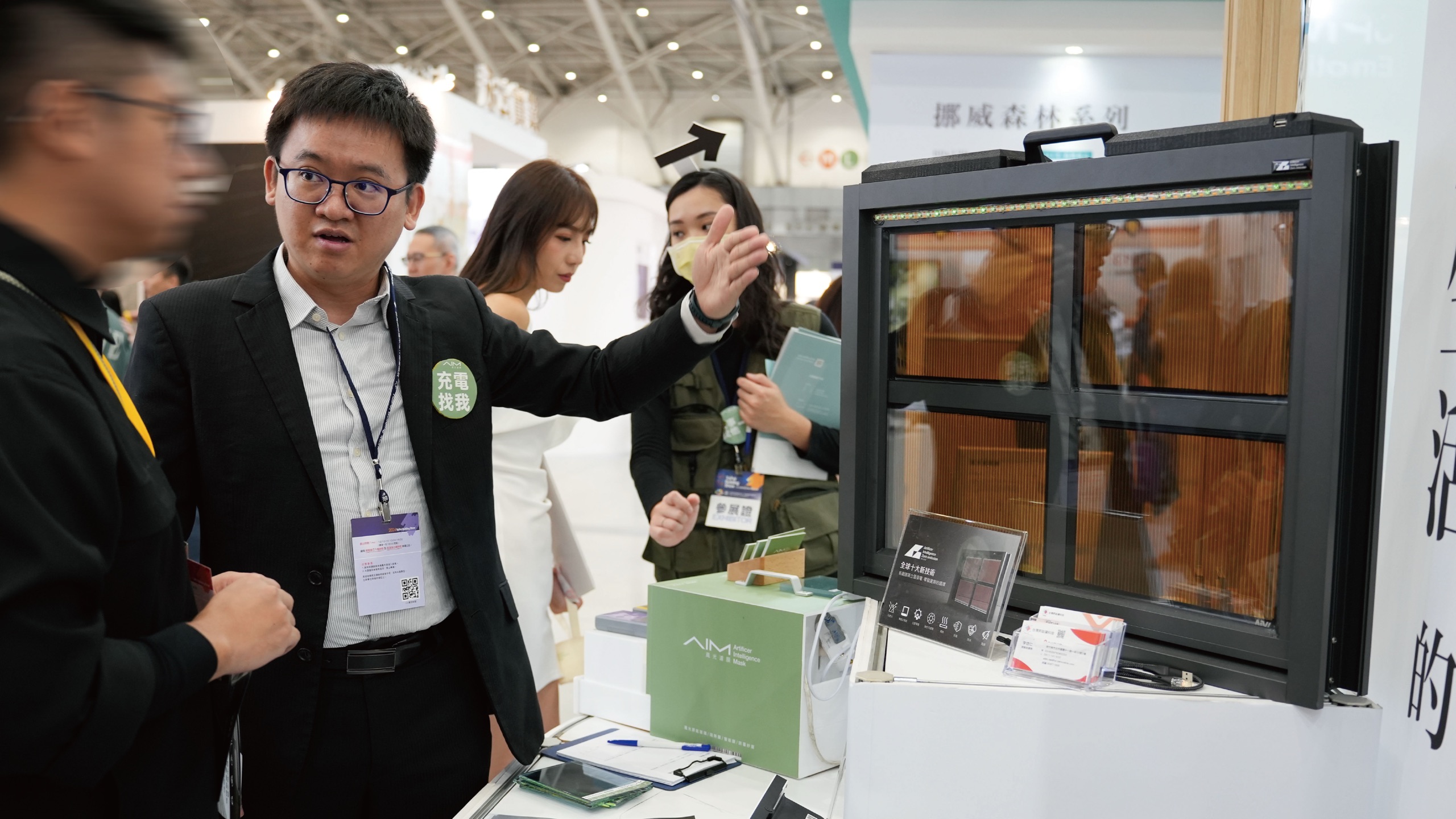 台北建材展 AIM 風光濾膜攤位：人員解說整合太陽能發電模組的智慧窗實品